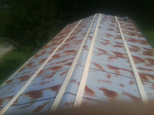 Rusted metal roof panels with new wood purlins before replacement — Storm Damage Roof Repair in Saint Peters by Roofing Brothers